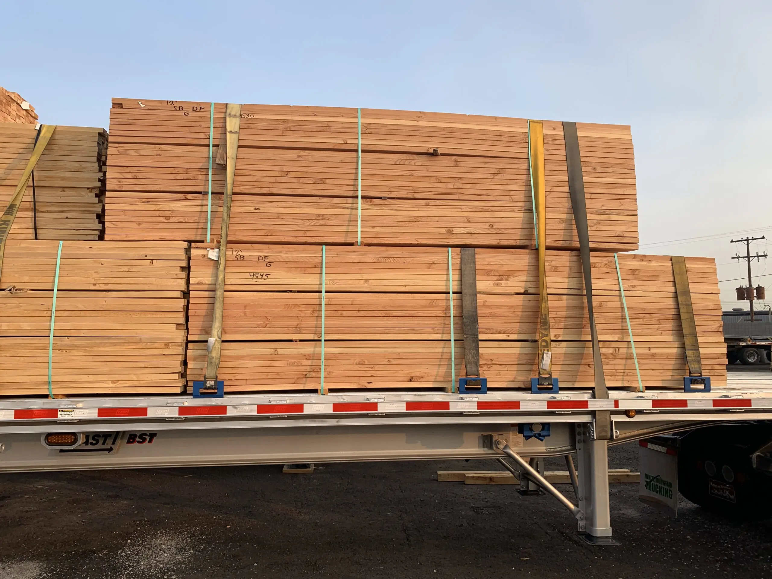 Lumber secured with straps on a flatbed trailer